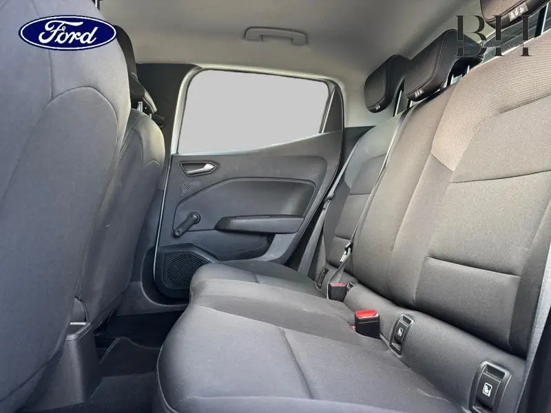 Vue intérieure arrière côté droit montrant la banquette tissu noir d'une Renault Clio blanche.