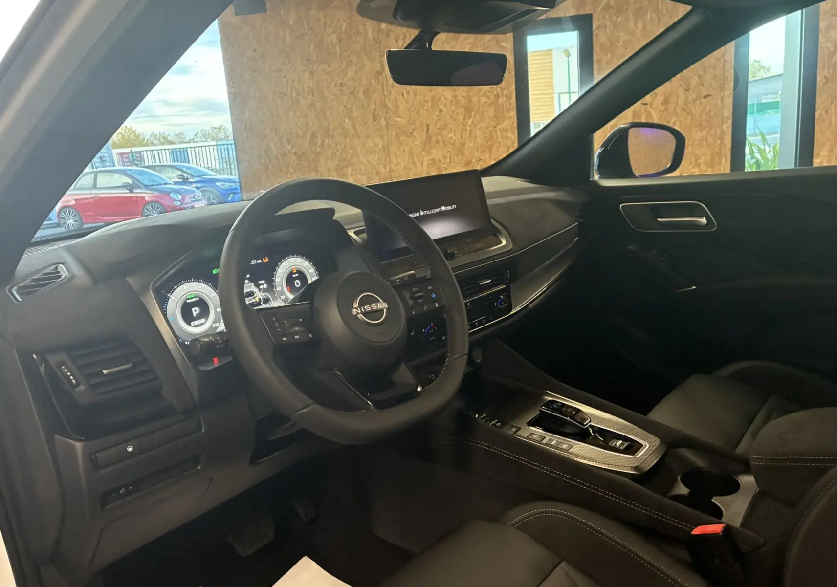 Vue intérieure côté conducteur du Nissan Qashqai 2025 avec tableau de bord numérique et finition noire élégante.