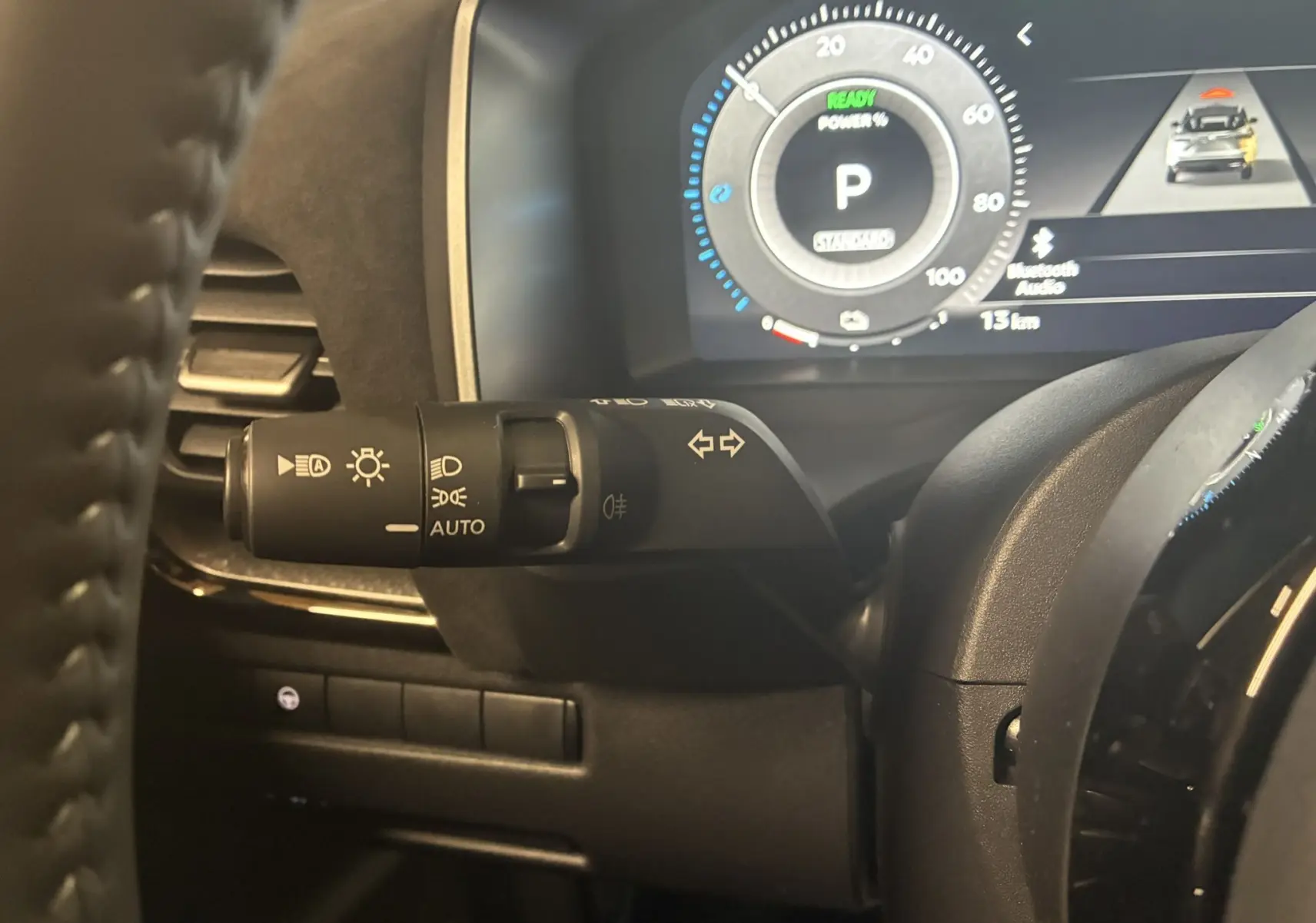 Gros plan sur la commande des phares et clignotants à gauche du volant du Nissan Qashqai blanc nacré 2025.