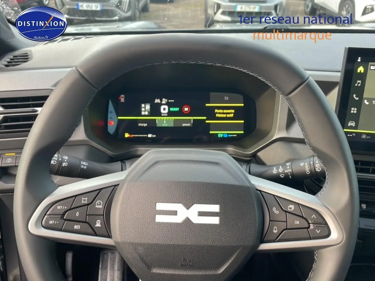 Vue rapprochée du volant en cuir noir du Dacia Bigster gris schiste, avec tableau de bord numérique et commandes intégrées.