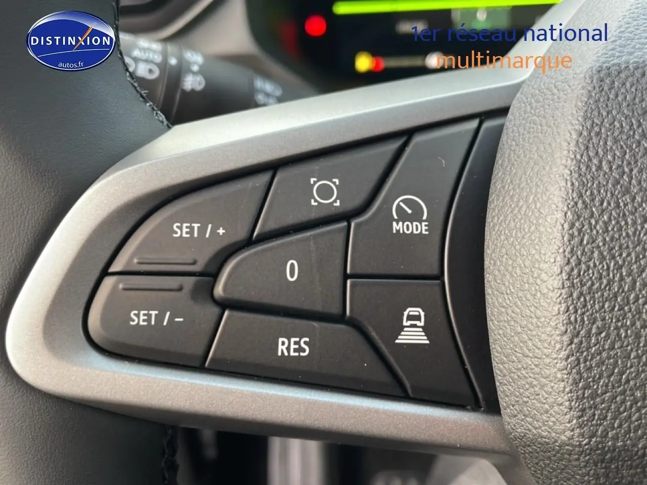 Gros plan sur les commandes au volant du Dacia Bigster gris schiste, mettant en valeur les boutons de régulateur et mode de conduite.