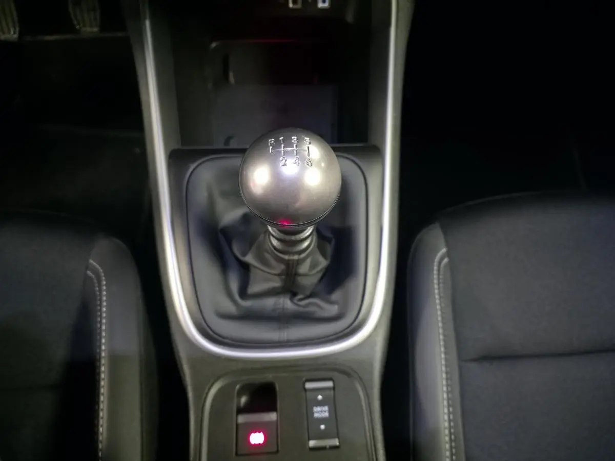 Gros plan sur le levier de vitesses manuel et la console centrale noire du Jeep Avenger 2025, sellerie tissu noir visible.