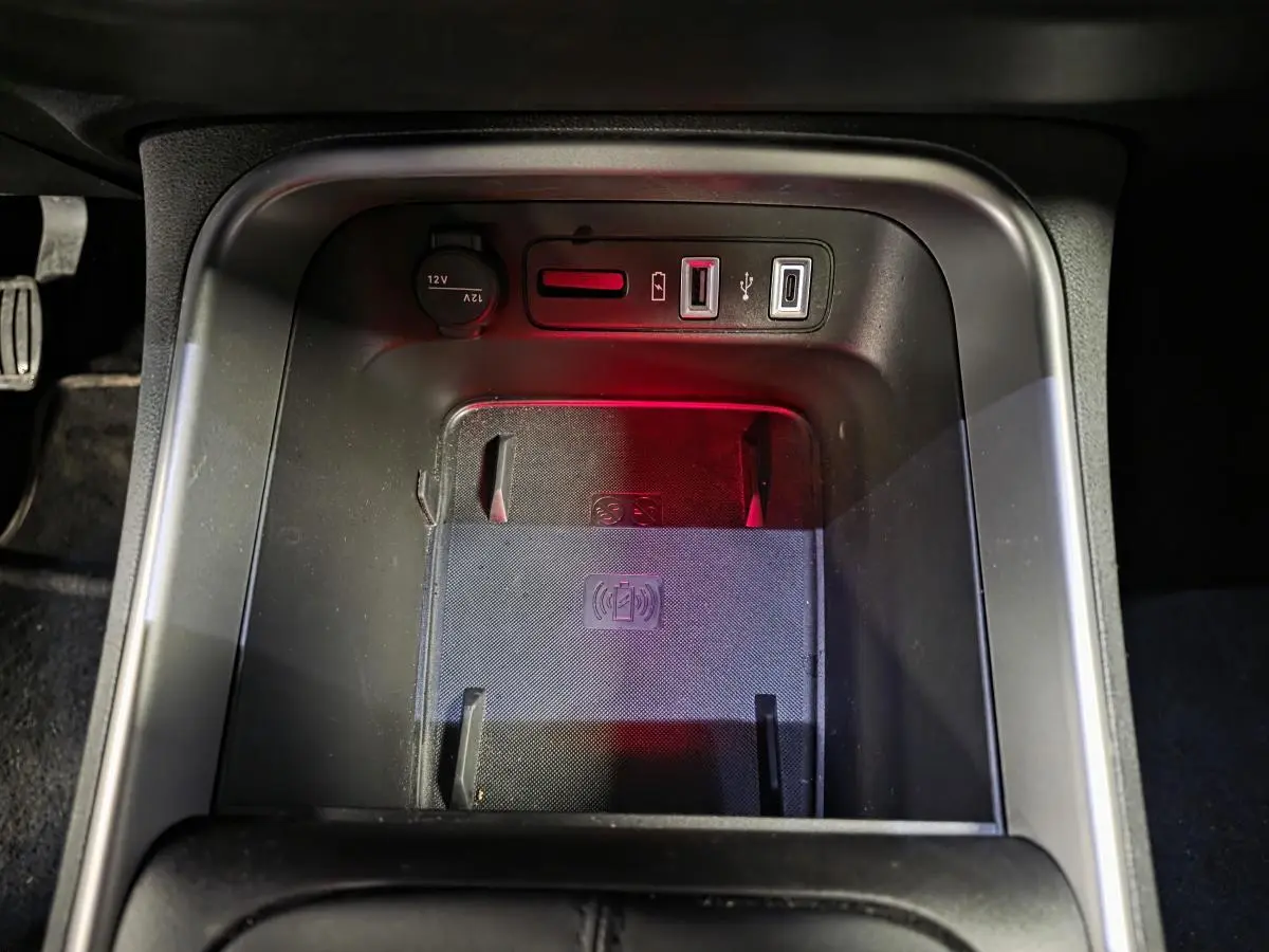 Gros plan sur la console centrale noire du Jeep Avenger 2025 avec chargeur sans fil et prises USB visibles.
