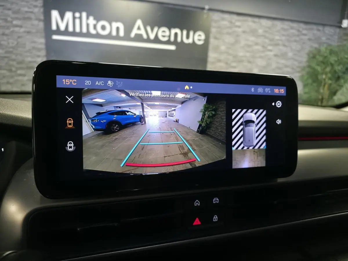 Écran tactile intérieur montrant la caméra de recul avec vue arrière et image 360°, tableau de bord noir.