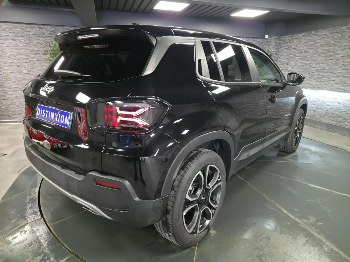 Jeep Avenger noir en vue 3/4 arrière droit, avec feux arrière LED et jantes alliage 18 pouces distinctives.