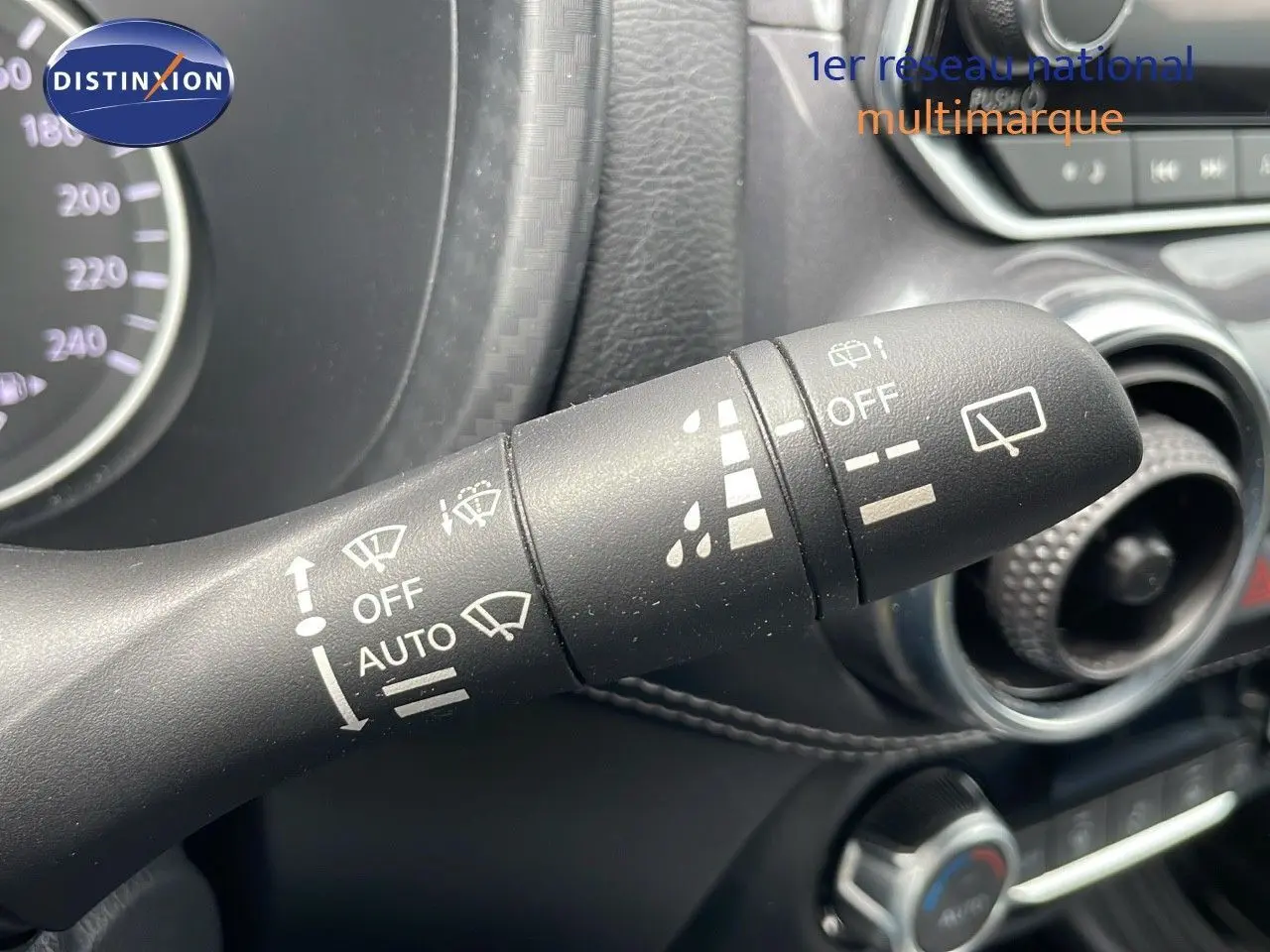 Gros plan sur la commande d'essuie-glace du Nissan Juke Hybrid 2023, intérieur noir avec détails blancs.