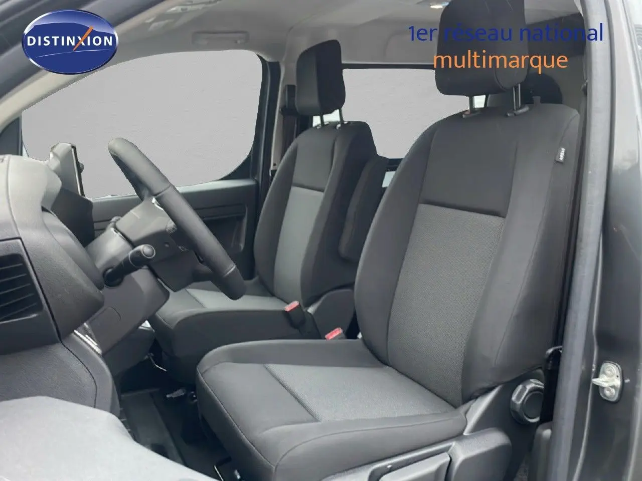 Vue intérieure côté gauche montrant les sièges avant en tissu noir du Citroën Jumpy Cabine Approfondie gris titane.