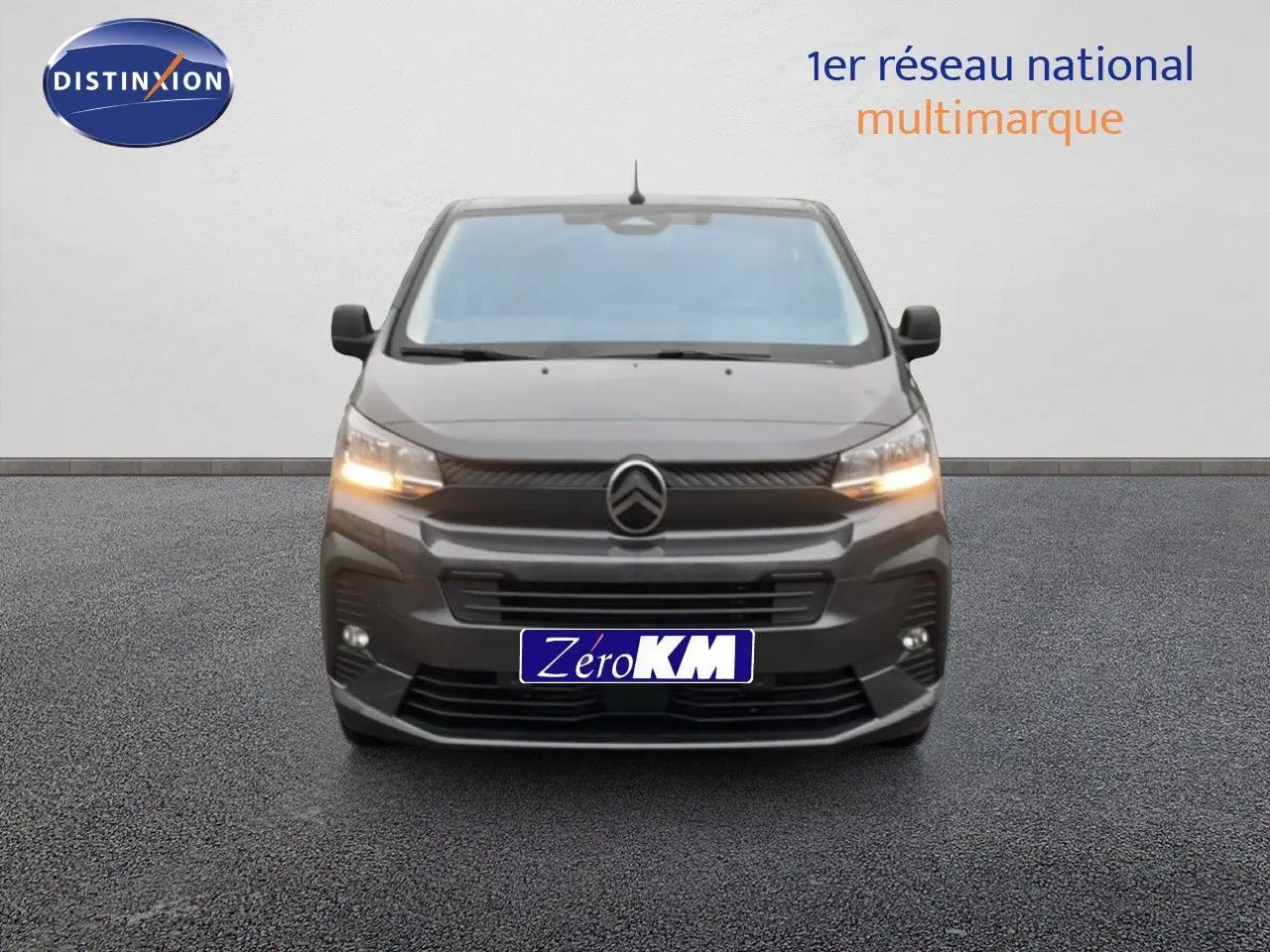 Vue frontale d'un Citroën Jumpy Cabine Approfondie gris titane métal avec feux allumés sur fond neutre.