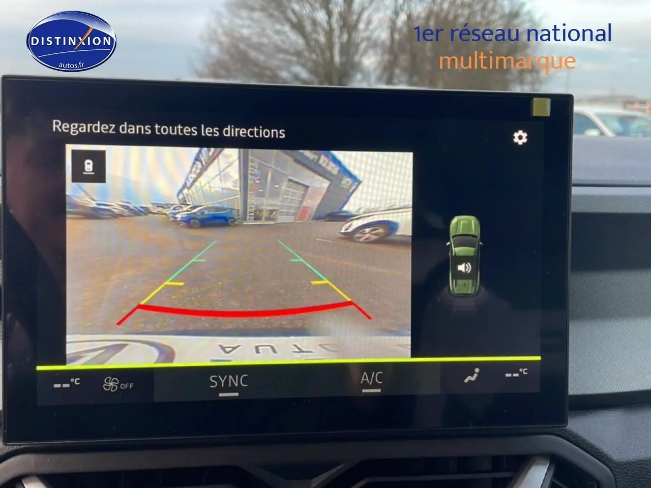 Vue intérieure de l'écran multimédia affichant la caméra de recul du Dacia Bigster gris schiste en stationnement.