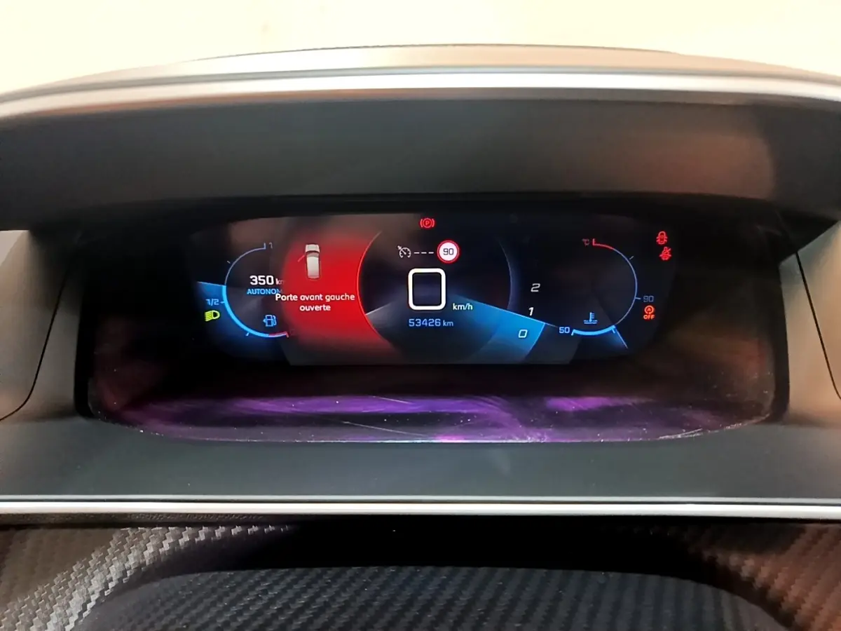 Affichage numérique du tableau de bord de la Peugeot 208 PureTech 100 S&S Allure Pack, indiquant porte avant gauche ouverte.