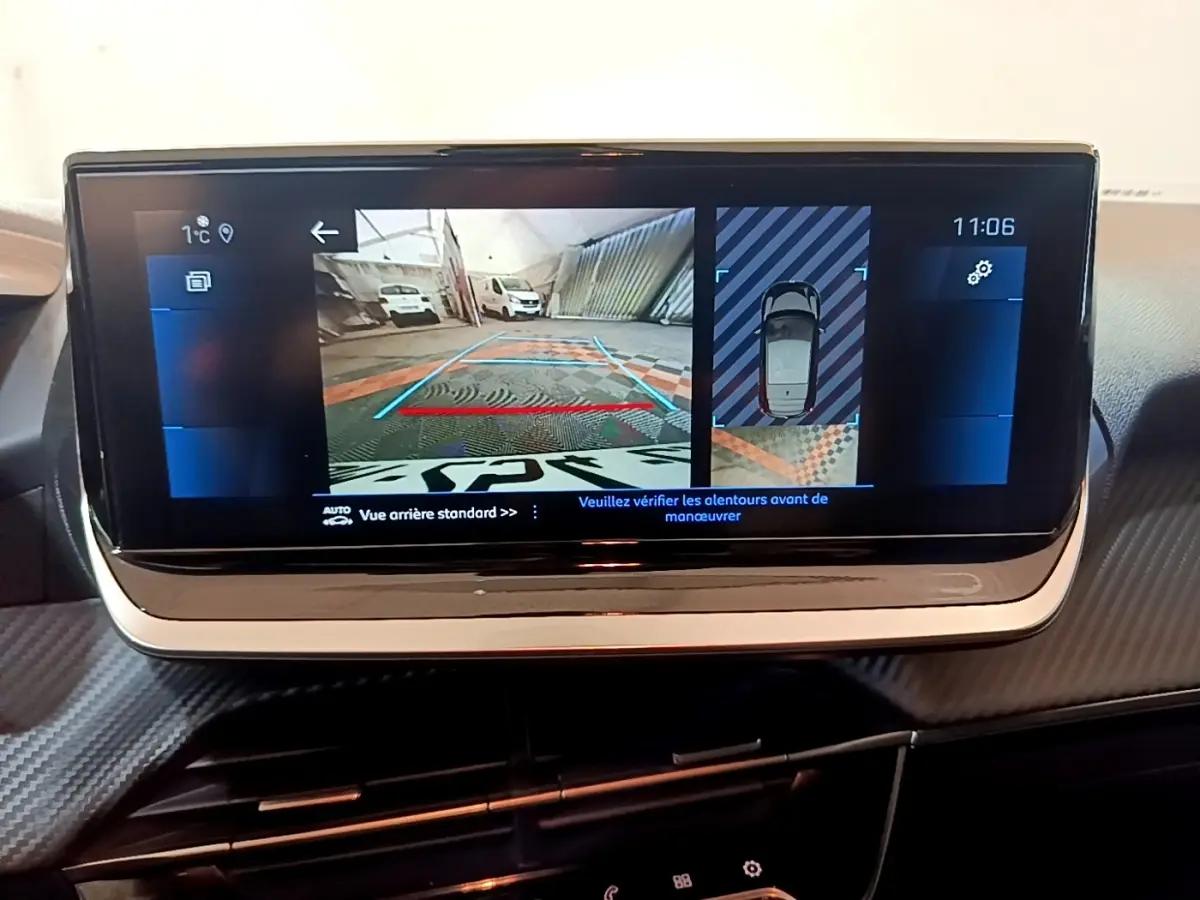 Écran tactile central de la Peugeot 208 jaune, affichant la caméra de recul et vue 360° intérieure.