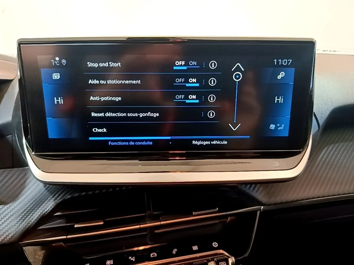 Écran tactile central de la Peugeot 208 jaune, affichant les réglages d'aide à la conduite, vue intérieure frontale.