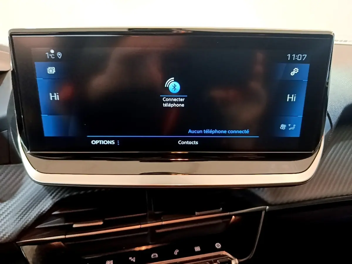 Écran tactile central 17,8 cm du tableau de bord de la Peugeot 208 jaune, affichant la connexion Bluetooth.