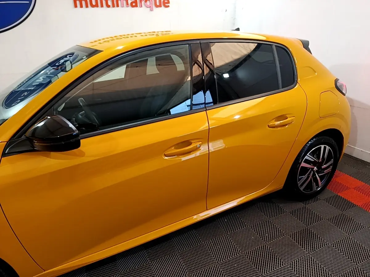 Vue latérale droite d'une Peugeot 208 jaune vif avec rétroviseur noir et jantes alliage modernes.