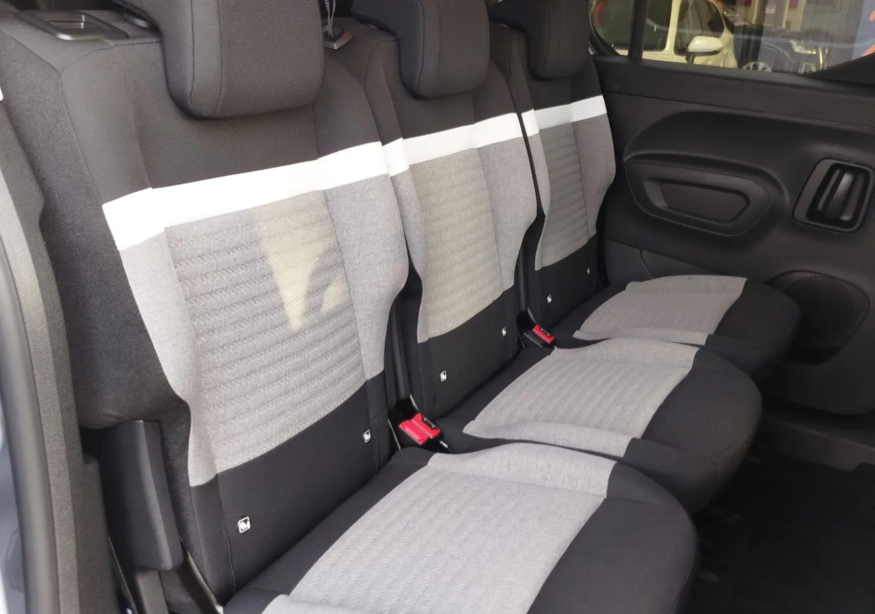 Vue latérale intérieure des sièges arrière gris clair et noir du Citroën Berlingo 2025, version 5 places.