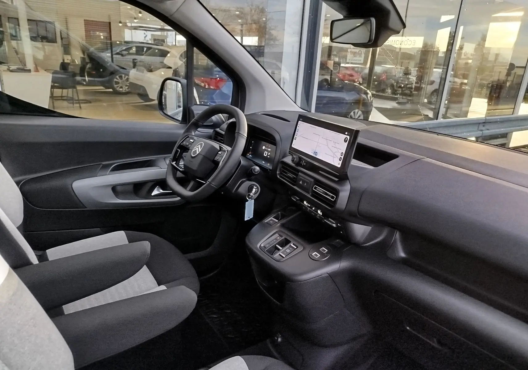 Vue intérieure côté conducteur du Citroën Berlingo gris acier 2025, avec tableau de bord moderne et écran tactile central.