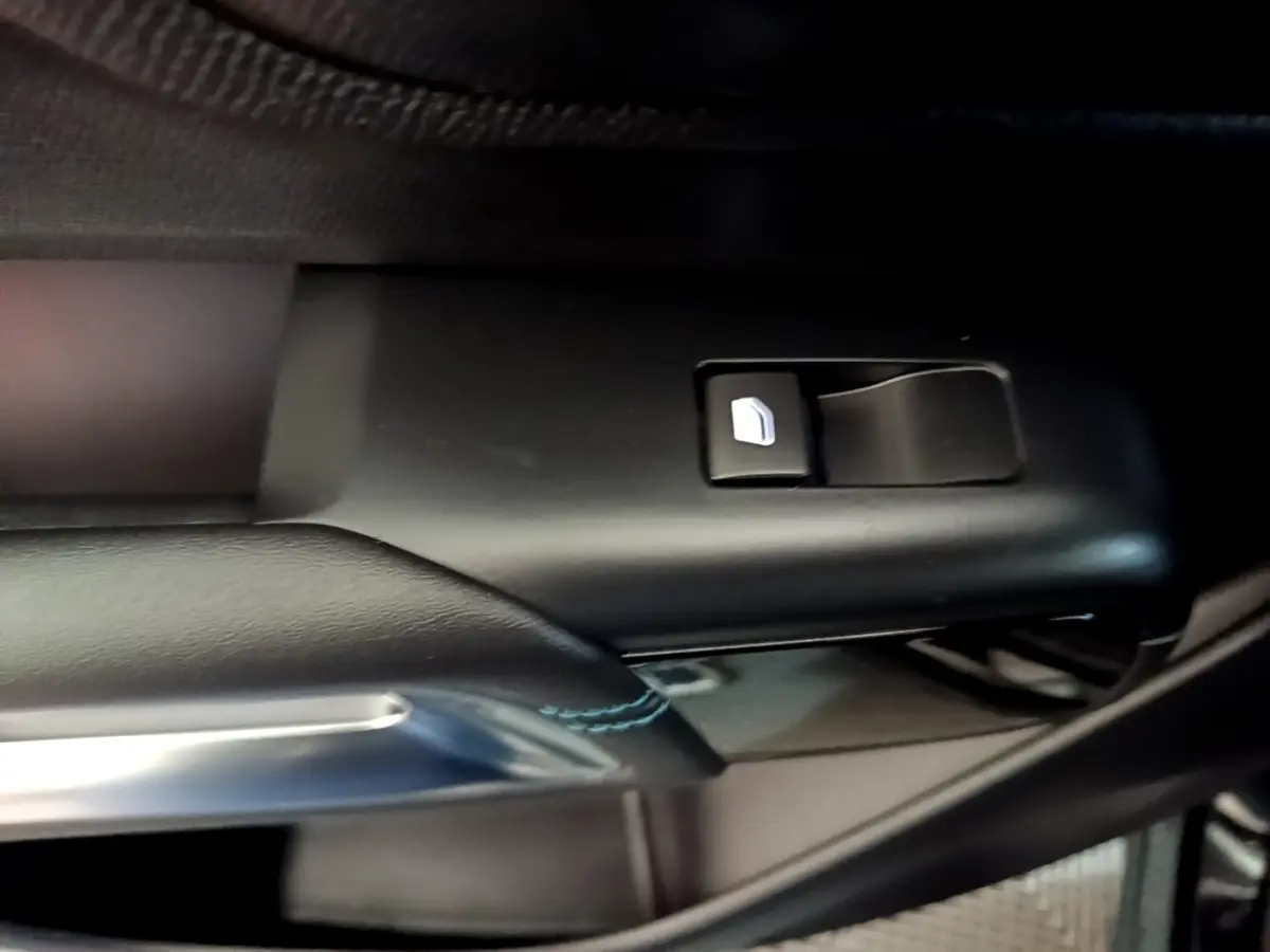 Détail de la commande de lève-vitre côté conducteur sur porte intérieure noire du Citroën C5 Aircross hybride 2022.