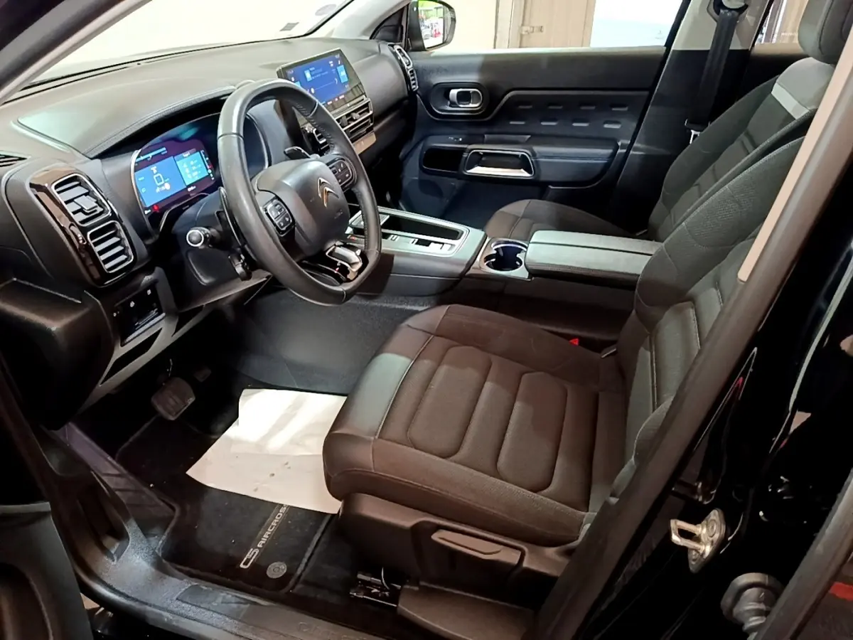 Vue intérieure côté conducteur du Citroën C5 Aircross hybride rechargeable noir, avec tableau de bord digital et sièges noirs.