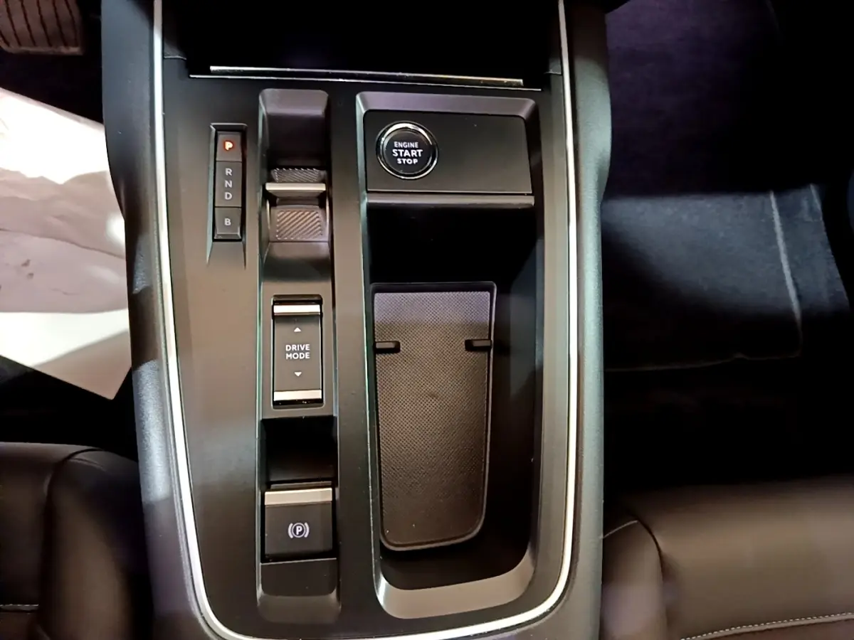 Vue rapprochée de la console centrale noire du Citroën C5 Aircross hybride avec bouton start/stop et commandes de boîte auto.