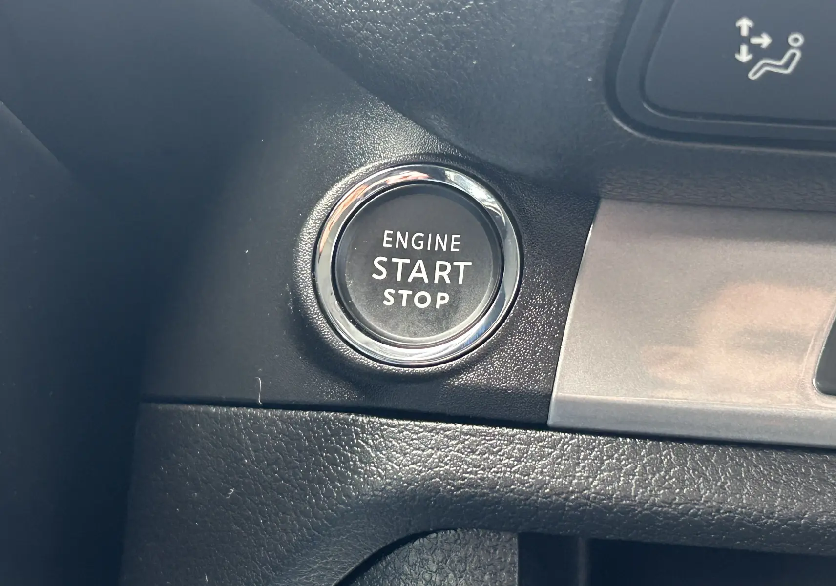 Bouton moteur start/stop rond avec contour chromé sur tableau de bord noir et insert gris du Citroën Jumpy Cabine Approfondie.