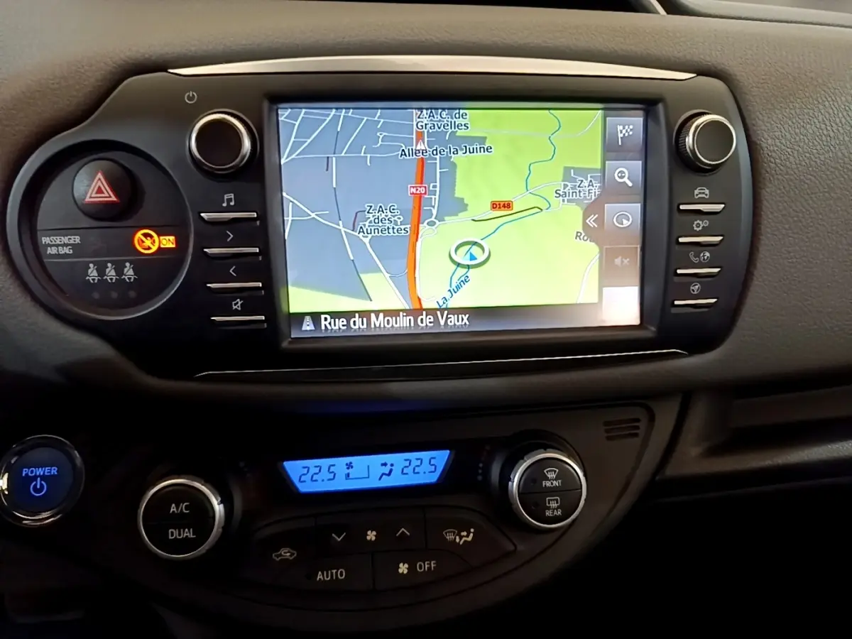 Vue rapprochée de l’écran tactile de navigation et de la console centrale noire de la Toyota Yaris blanche 2019.