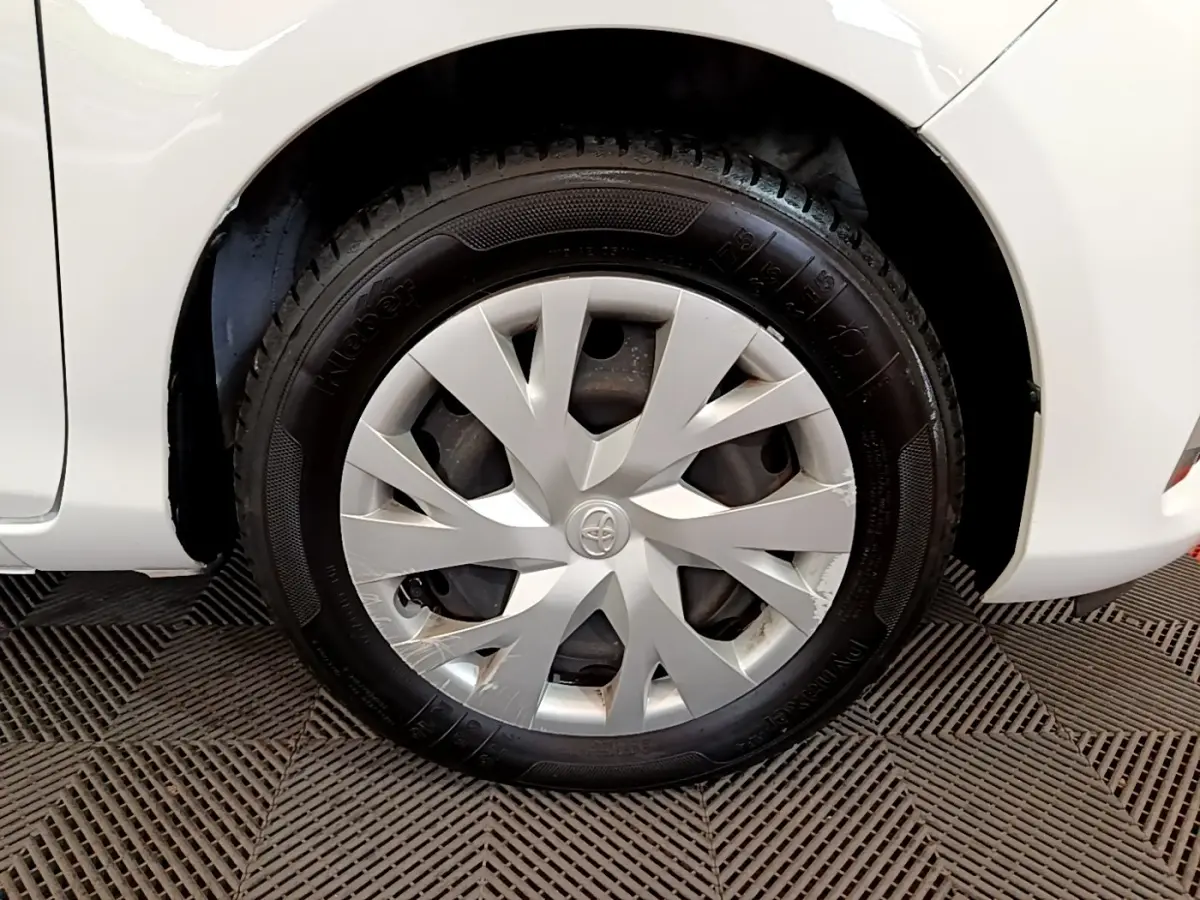 Gros plan sur la roue arrière droite blanche d'une Toyota Yaris 2019 avec enjoliveur gris et logo Toyota central.