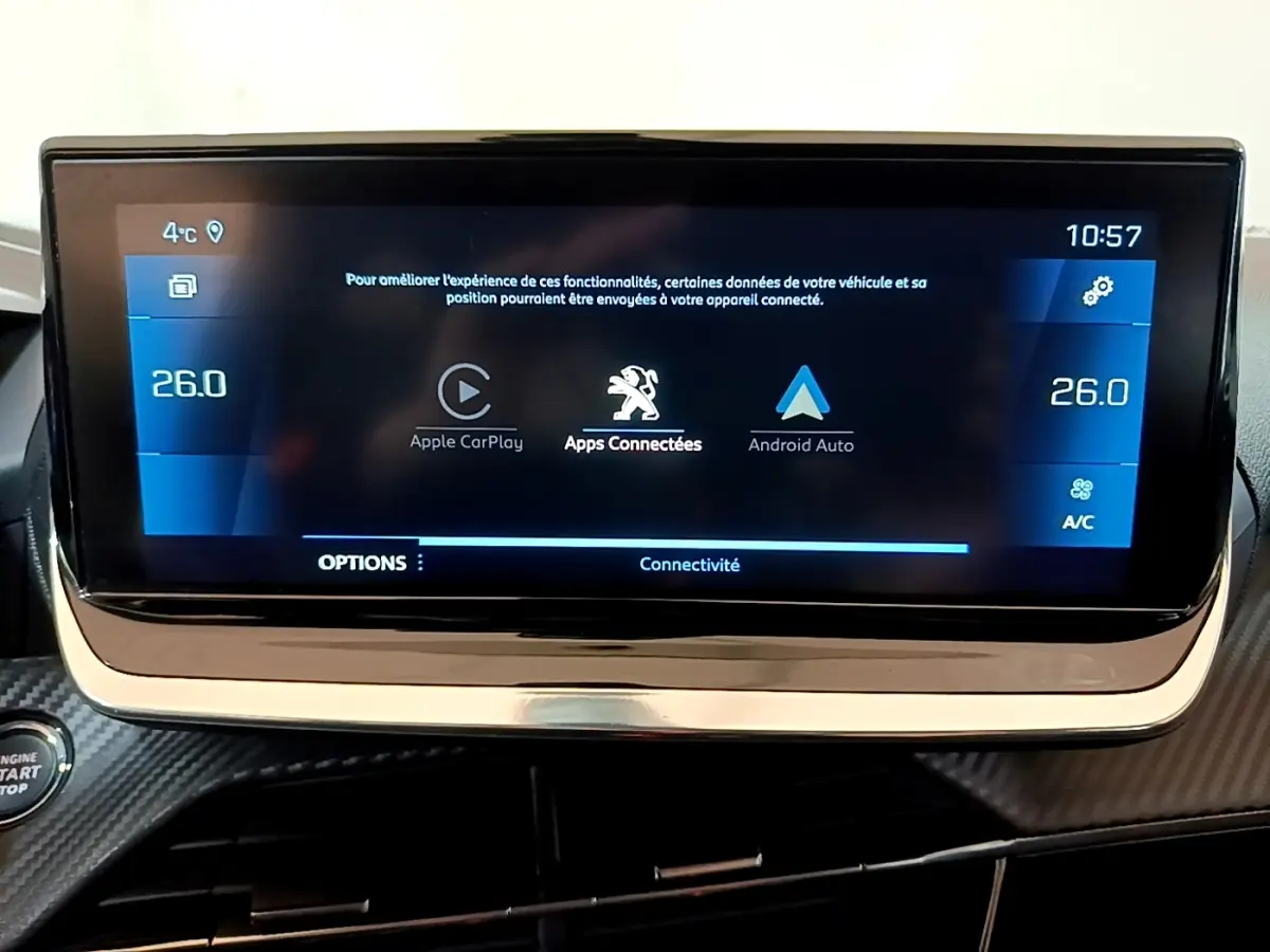Vue intérieure centrée sur l'écran tactile 10 pouces du tableau de bord de la Peugeot 208 blanche, affichant Apple CarPlay et Android Auto.