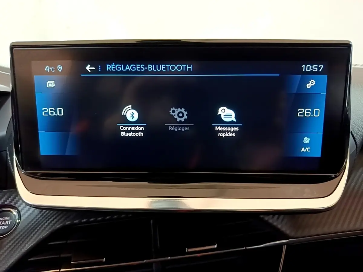 Écran tactile central de la Peugeot 208 blanc, affichant les réglages Bluetooth et la température à 26°C.