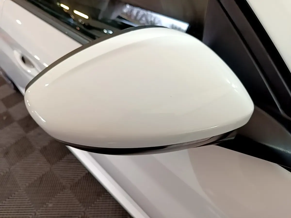Rétroviseur blanc côté conducteur d'une Peugeot 208 PureTech 100 S&S Allure Business 2021, vue rapprochée en intérieur.