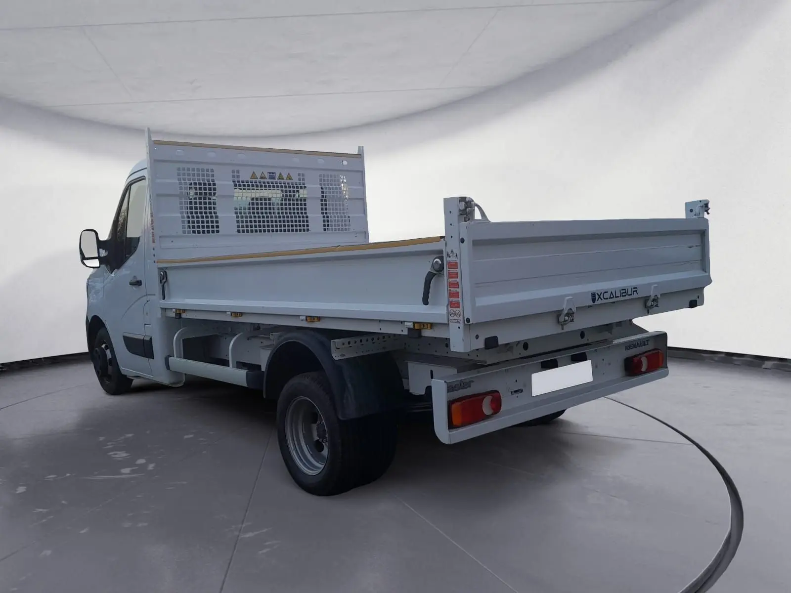 Renault Master Benne blanc vu 3/4 arrière droit, châssis cabine avec ridelles et roues jumelées.