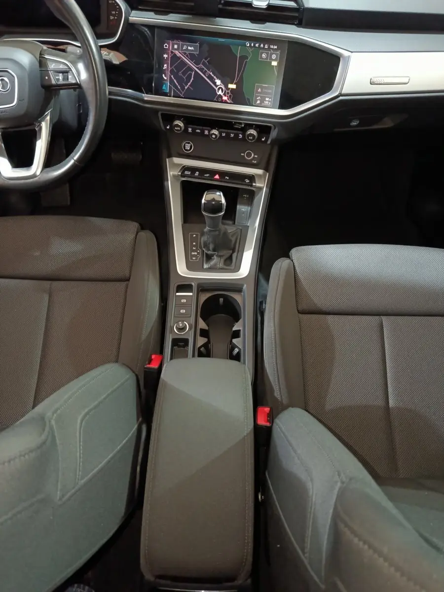 Vue intérieure centrée sur la console centrale et les sièges gris foncé de l'Audi Q3 Sportback 45 TFSI e 2021.