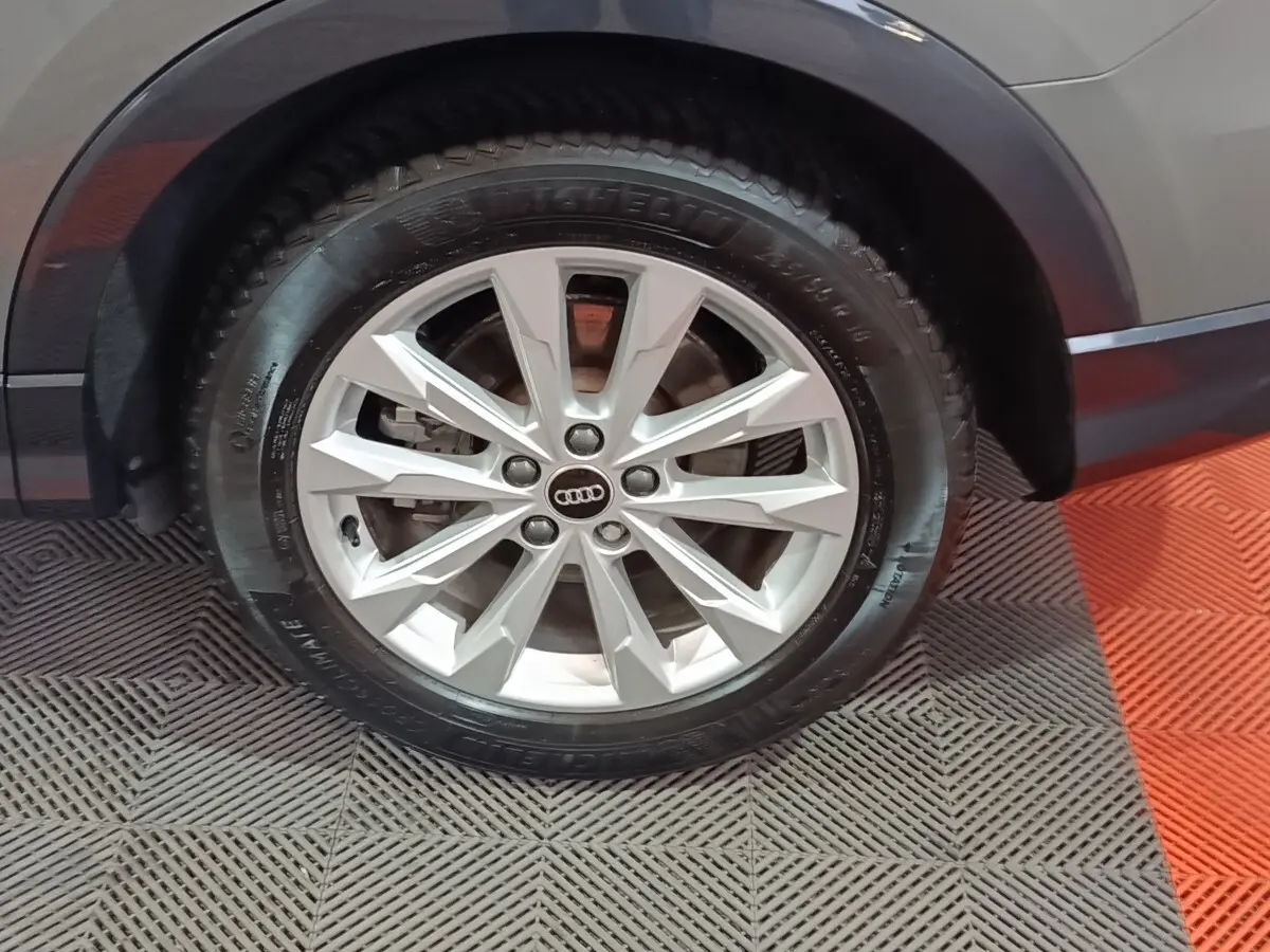 Gros plan sur la roue avant droite grise d’un Audi Q3 Sportback 45 TFSI e avec jante argentée multifacettes.
