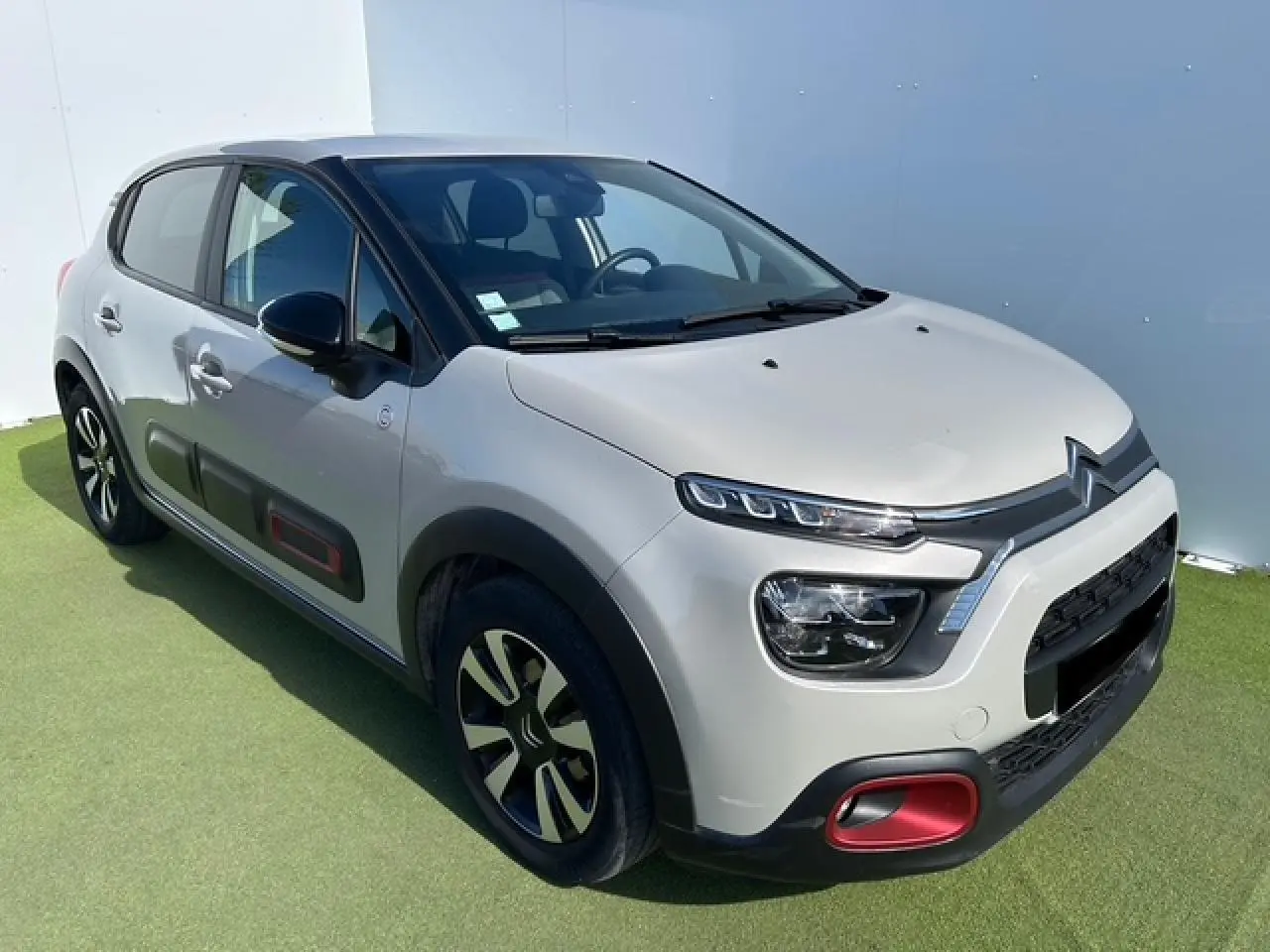 Citroën C3 sable métallisé vue 3/4 avant droit avec inserts rouges et coques de rétroviseurs noires.
