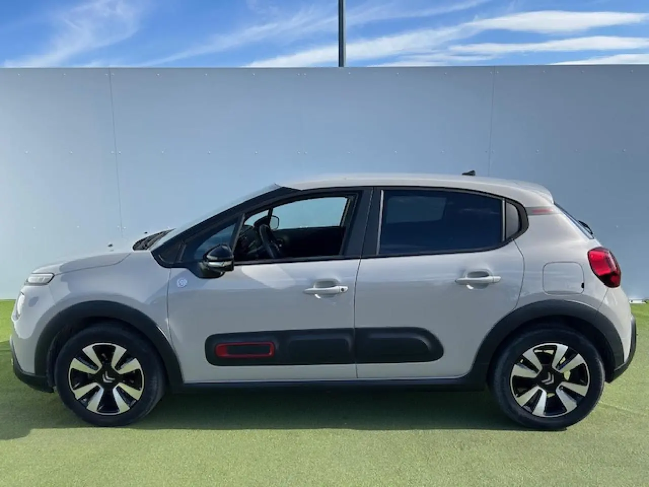 Profil côté gauche de la Citroën C3 sable métal 2021 avec protections latérales noires et jantes alliage diamantées.