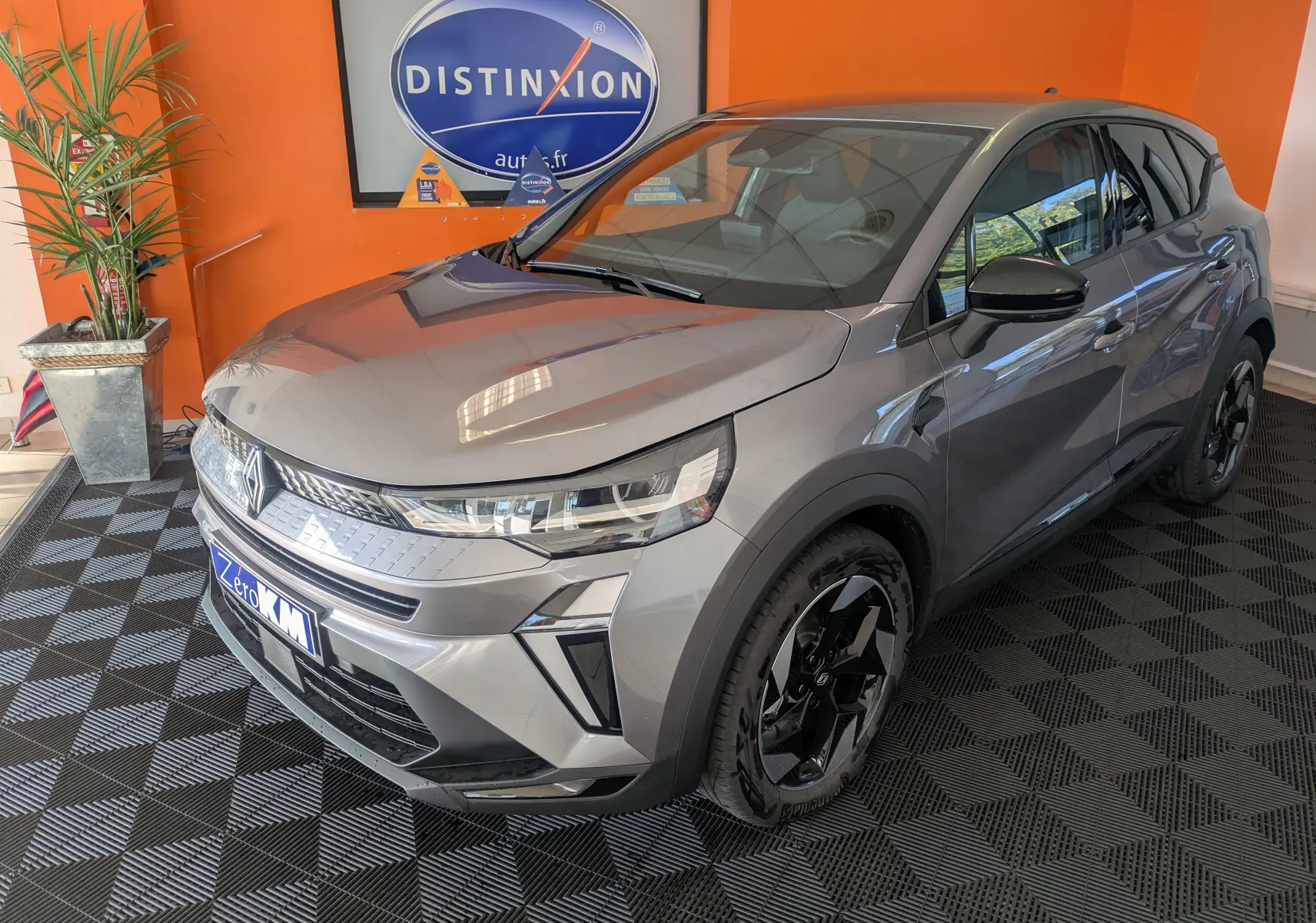 Renault Captur E-Tech gris cassiopée en 3/4 avant droit avec jantes noires et rétroviseurs brillants noirs.