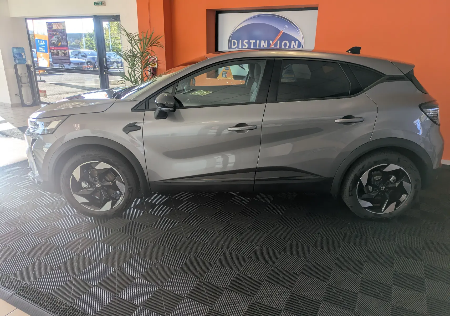 Profil côté gauche du Renault Captur E-Tech Full Hybrid 160 en gris Cassiopée avec jantes alliage 18'' Blackhole en showroom.