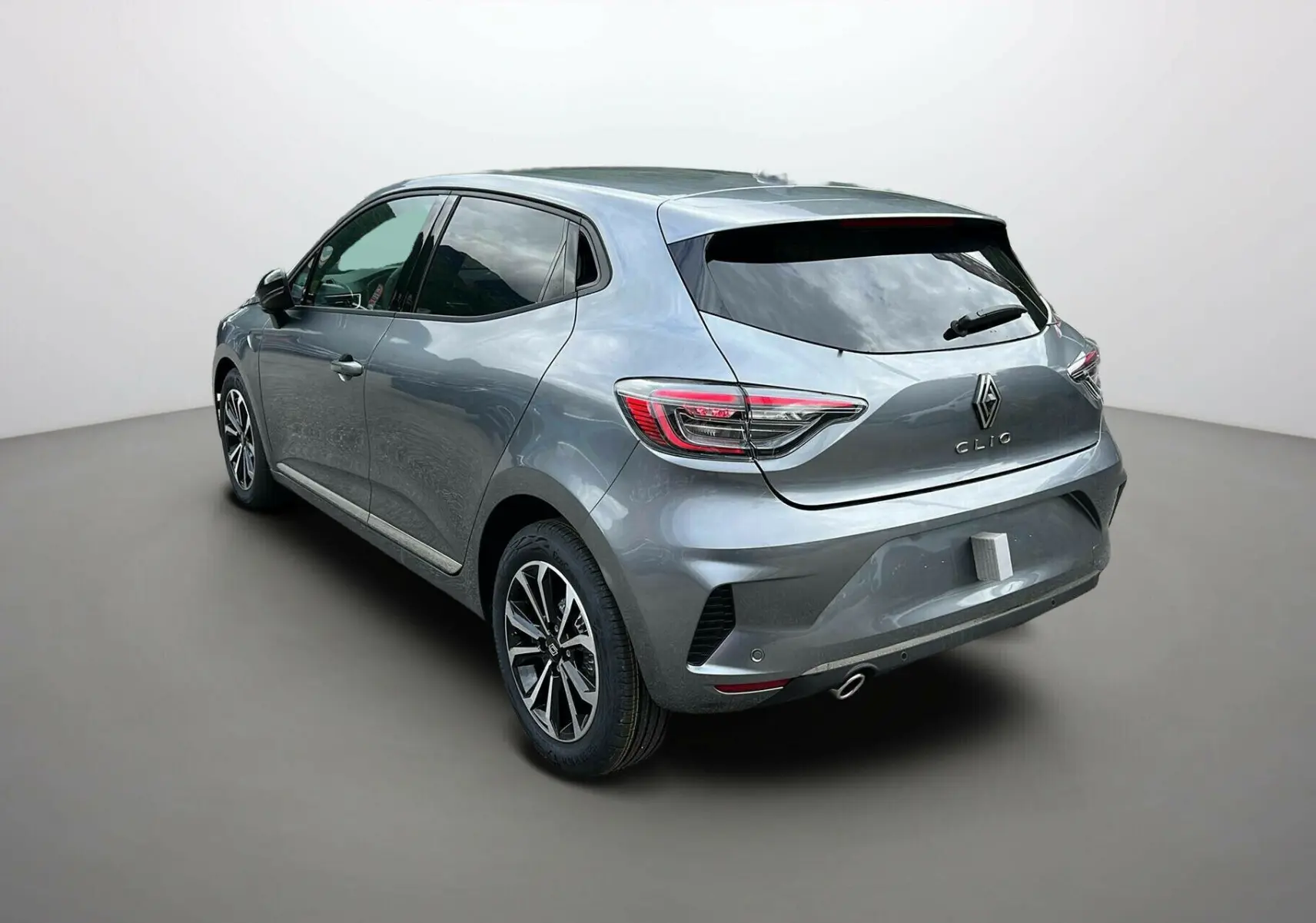 Renault Clio V TCe 90 Techno gris schiste vue 3/4 arrière côté gauche avec feux arrière LED distinctifs.
