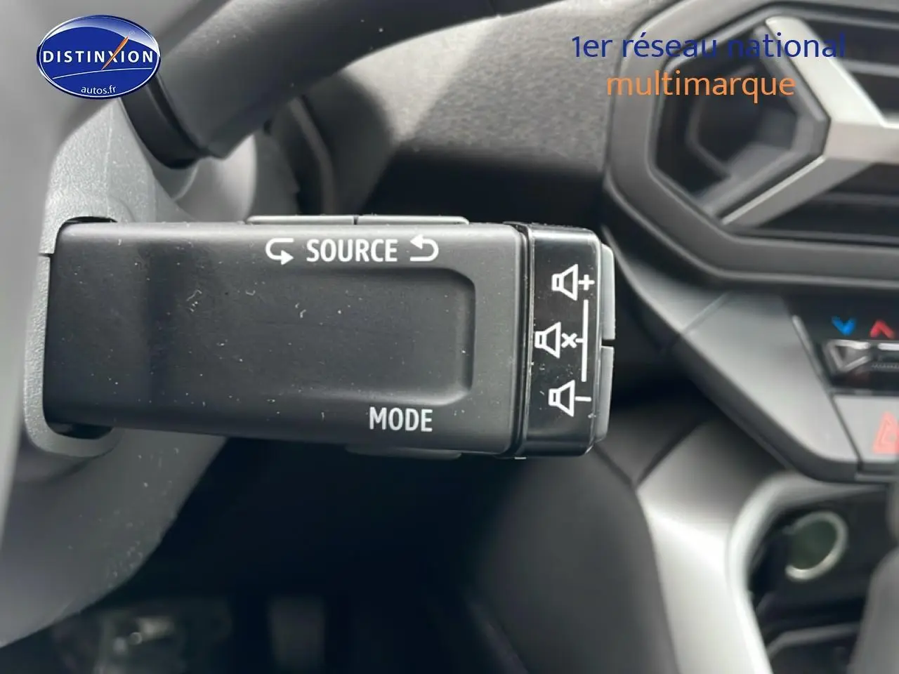 Gros plan sur la commande multimédia au volant du Dacia Bigster noir, intérieur avec tableau de bord partiel visible.