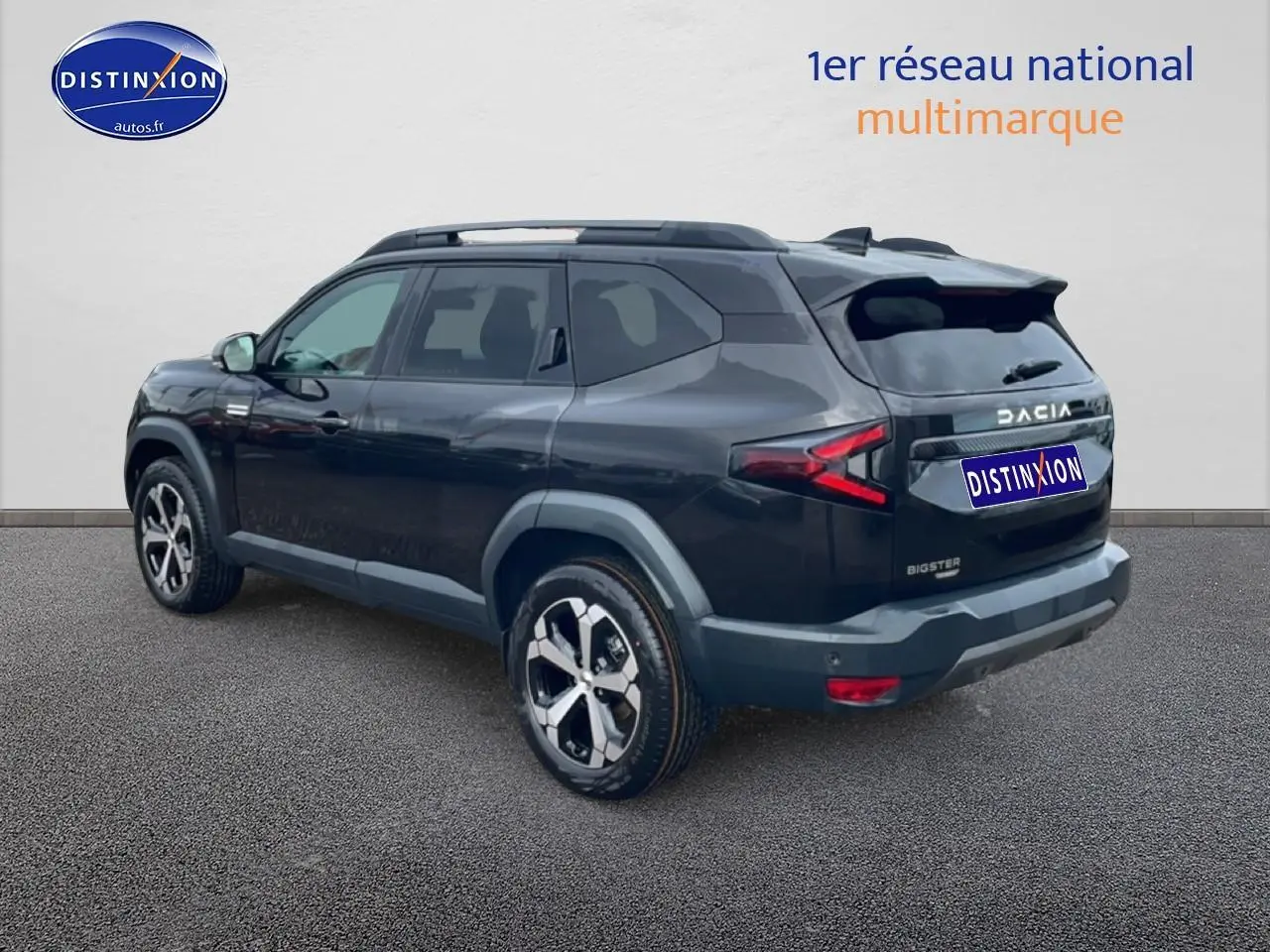 Vue 3/4 arrière droite du SUV Dacia Bigster noir 2025 avec jantes alliage diamantées et barres de toit.