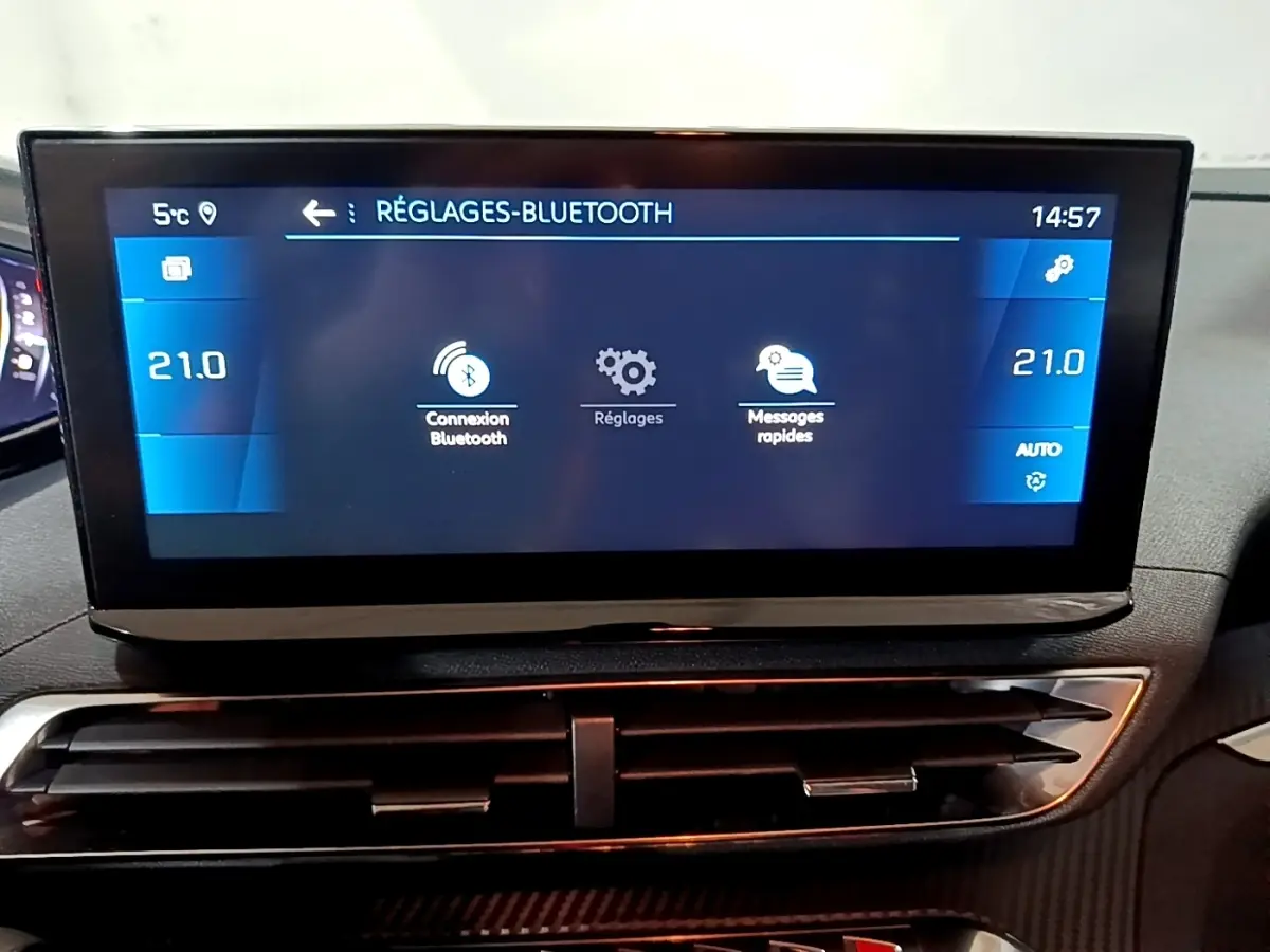 Écran tactile central du tableau de bord du Peugeot 5008 noir, affichant les réglages Bluetooth et la climatisation à 21°C.