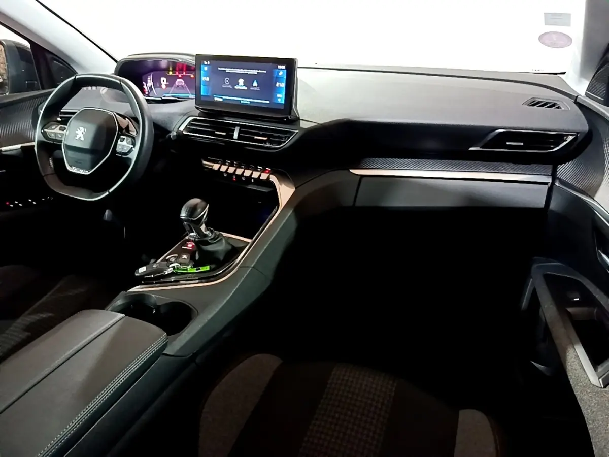 Intérieur noir du Peugeot 5008 PureTech 130, vue de face côté conducteur avec écran tactile et volant cuir multifonctions.