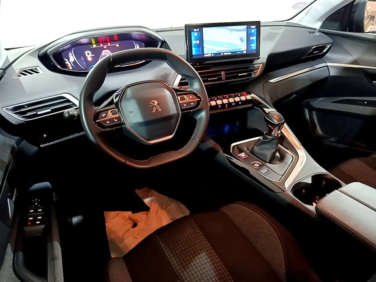 Intérieur noir du Peugeot 5008 PureTech 130, vue du poste de conduite avec volant compact et écran tactile central.