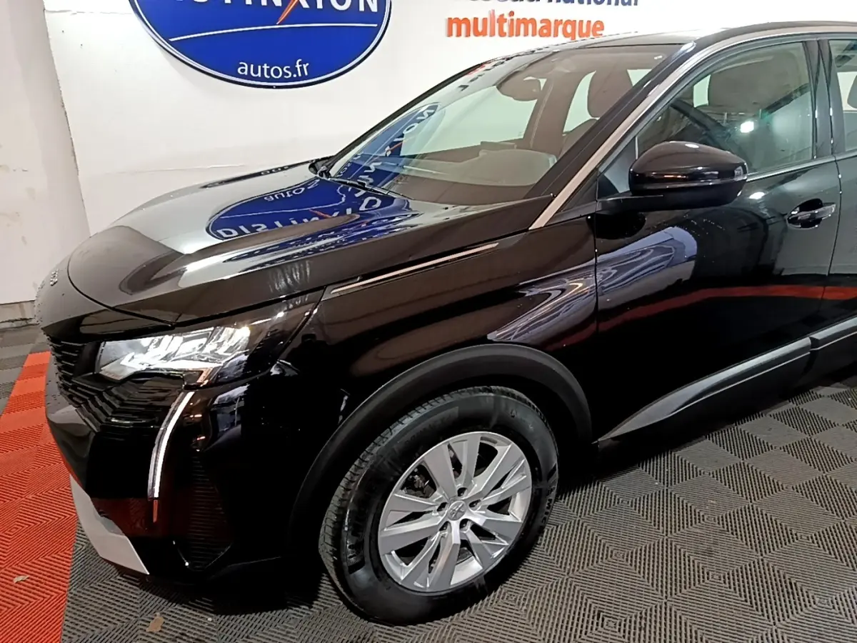 Peugeot 5008 noir vue 3/4 avant droit, mettant en valeur les phares LED et la calandre distinctive.