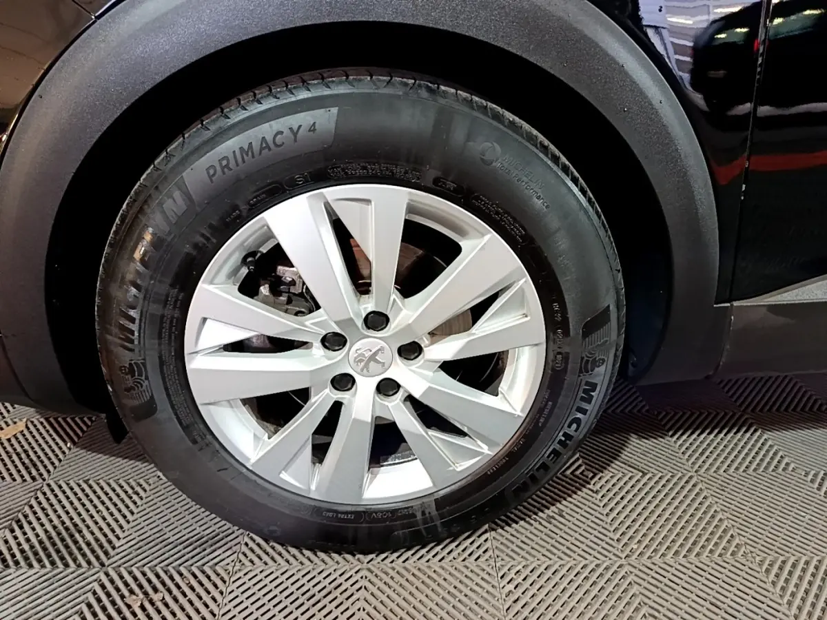 Gros plan sur la roue avant gauche du Peugeot 5008 noir, avec jante alliage et pneu Michelin Primacy 4.