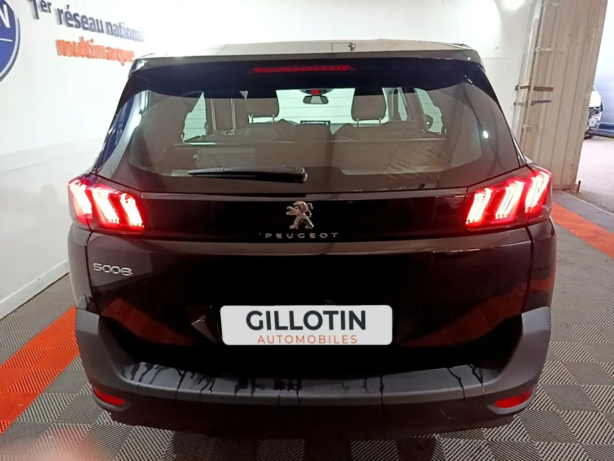 Vue arrière d’un Peugeot 5008 noir avec feux LED allumés dans un garage, plaque GILLOTIN visible.