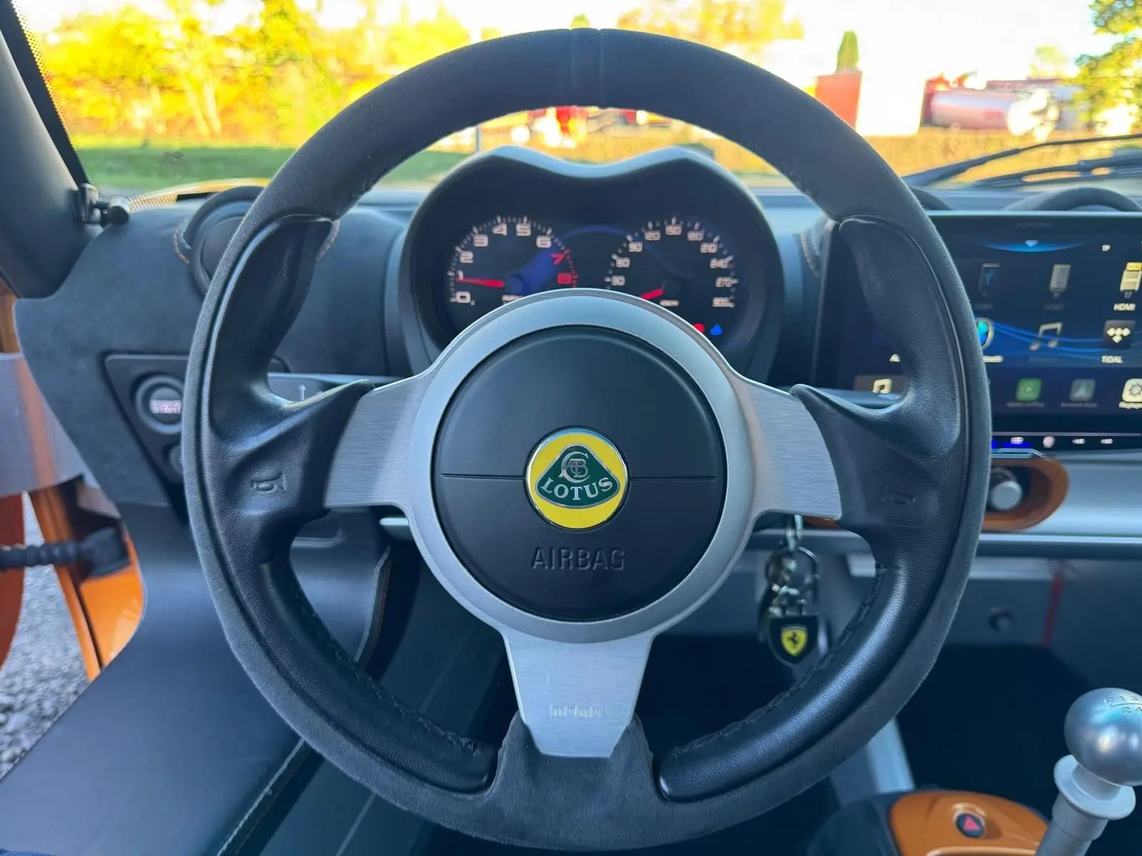 Vue centrée sur le volant cuir noir de la Lotus Elise 3 Cup 250 2021 avec tableau de bord et levier de vitesses alu visible.