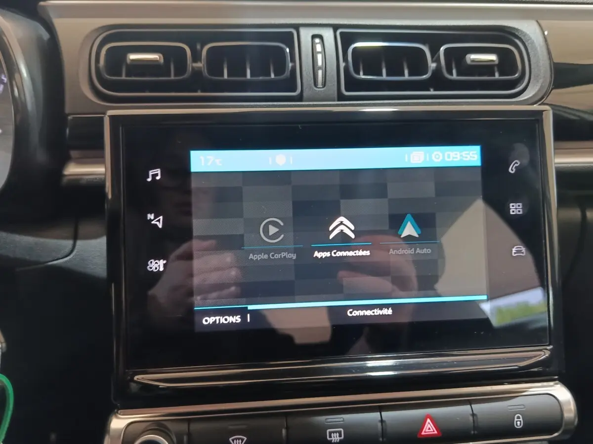 Vue rapprochée de l'écran tactile central noir du tableau de bord d'une Citroën C3 blanche, affichant Apple CarPlay et Android Auto.