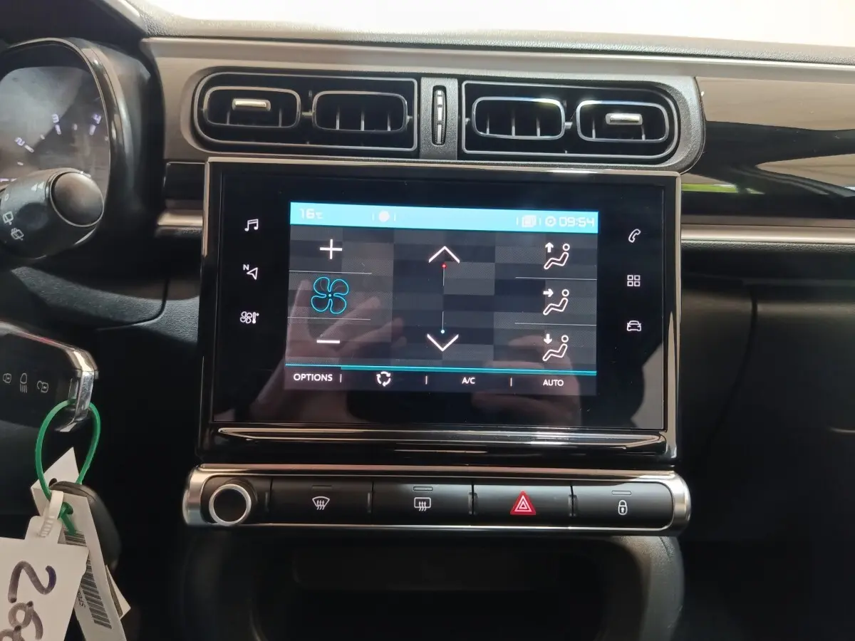 Vue rapprochée de l’écran tactile central et des commandes de climatisation d’une Citroën C3 blanche de 2020.