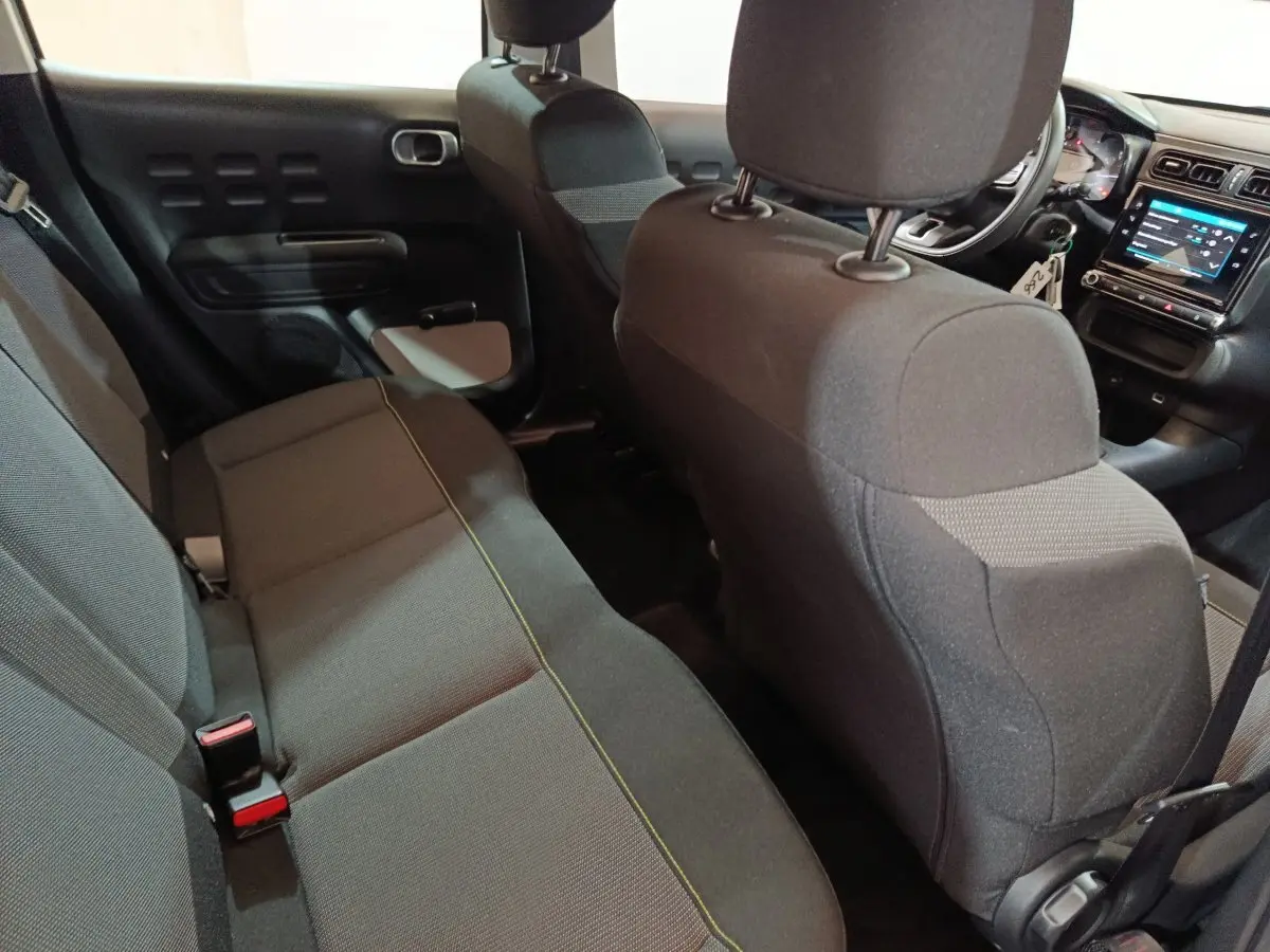 Vue intérieure arrière montrant la banquette noire et le tableau de bord avec écran tactile de la Citroën C3 2020.
