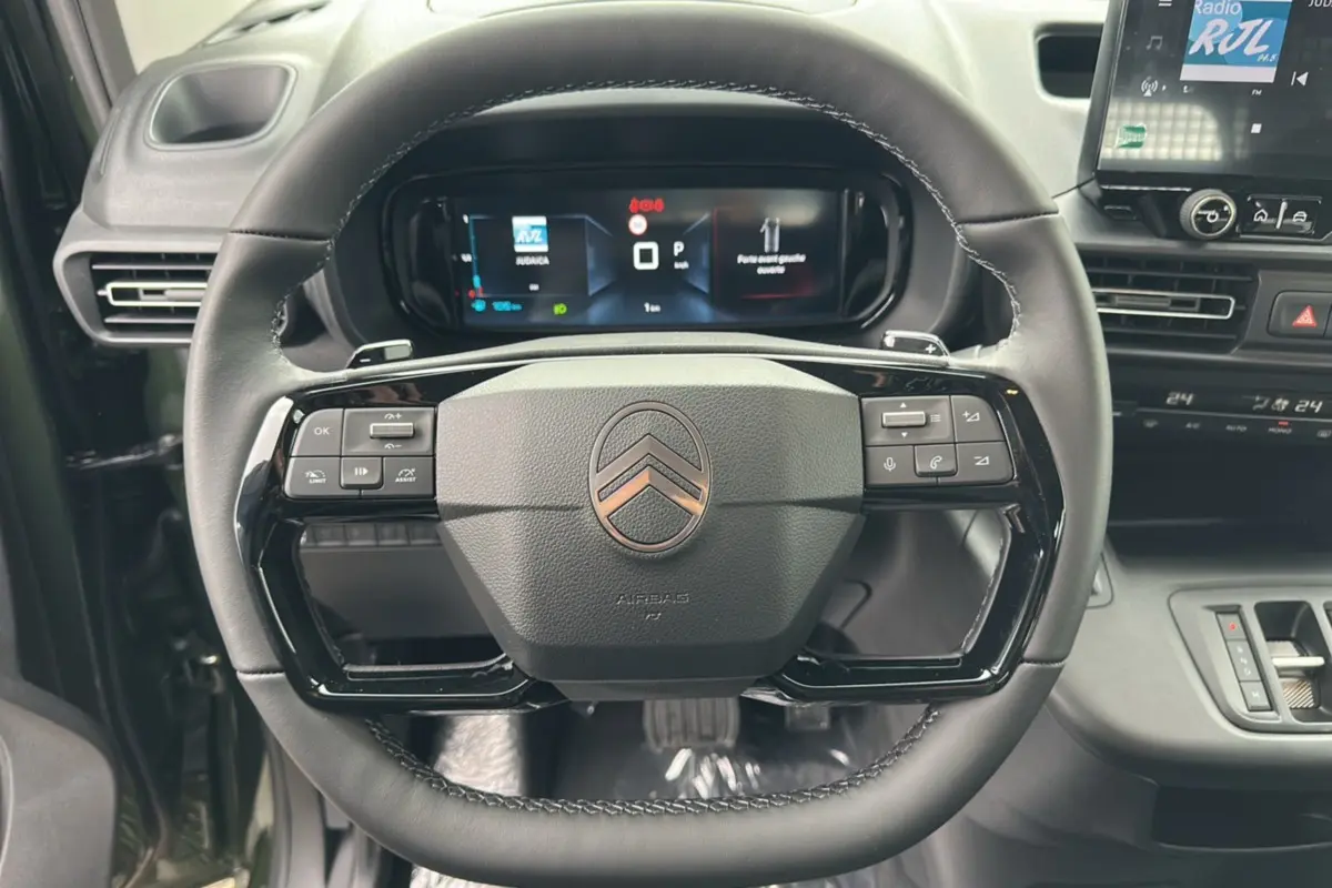 Vue rapprochée du volant noir du Citroën Berlingo 2025 avec commandes intégrées et tableau de bord numérique.